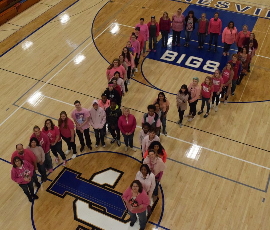 Students+and+staff+form+a+pink+ribbon+to+stand+up+for+breast+cancer+awareness+and+research.