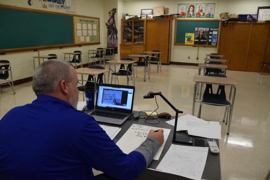 Math teacher Mr. Budrow teaches with his document camera as he works through a problem with students.