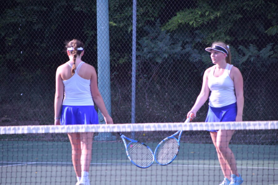Craigs #1 doubles team of Karyssa Norland (left) and Addison Kooyman touch rackets after a winning point.